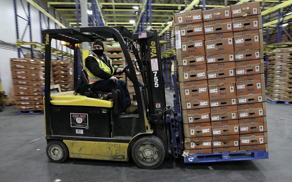 Depoda kutulu ürünleri taşıyan forklift.